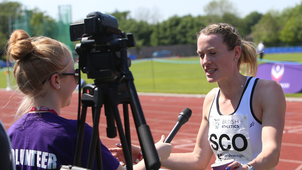 an athlete being interviewed next to the running track